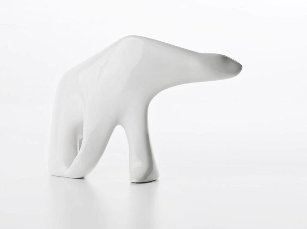 A polar bear figurine depicted in motion, made entirely of white porcelain. It is just a form with no painted facial features.
