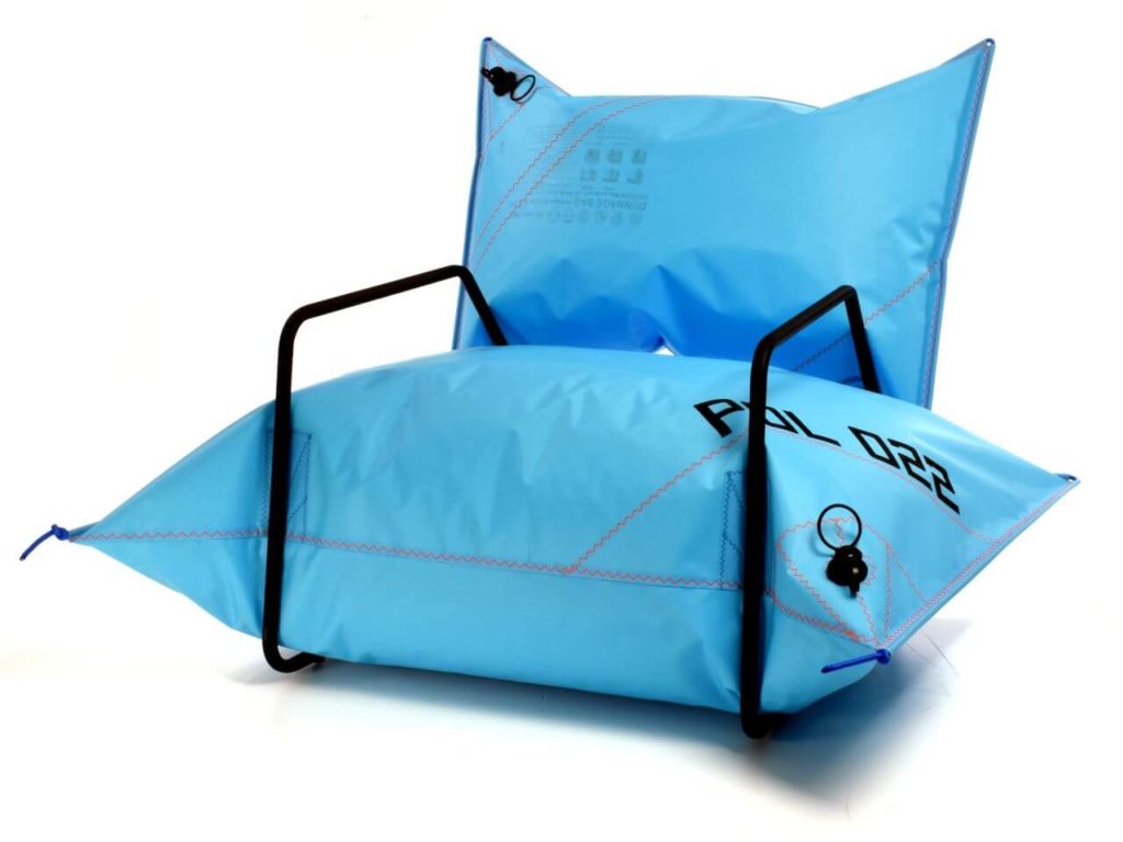 An unusual armchair with no legs. It's made out of two pillows-shaped inflatable blue paper bags. They function as both a seat and a backrest. The black steel rod constructions, which also serve as armrests, connect them.
