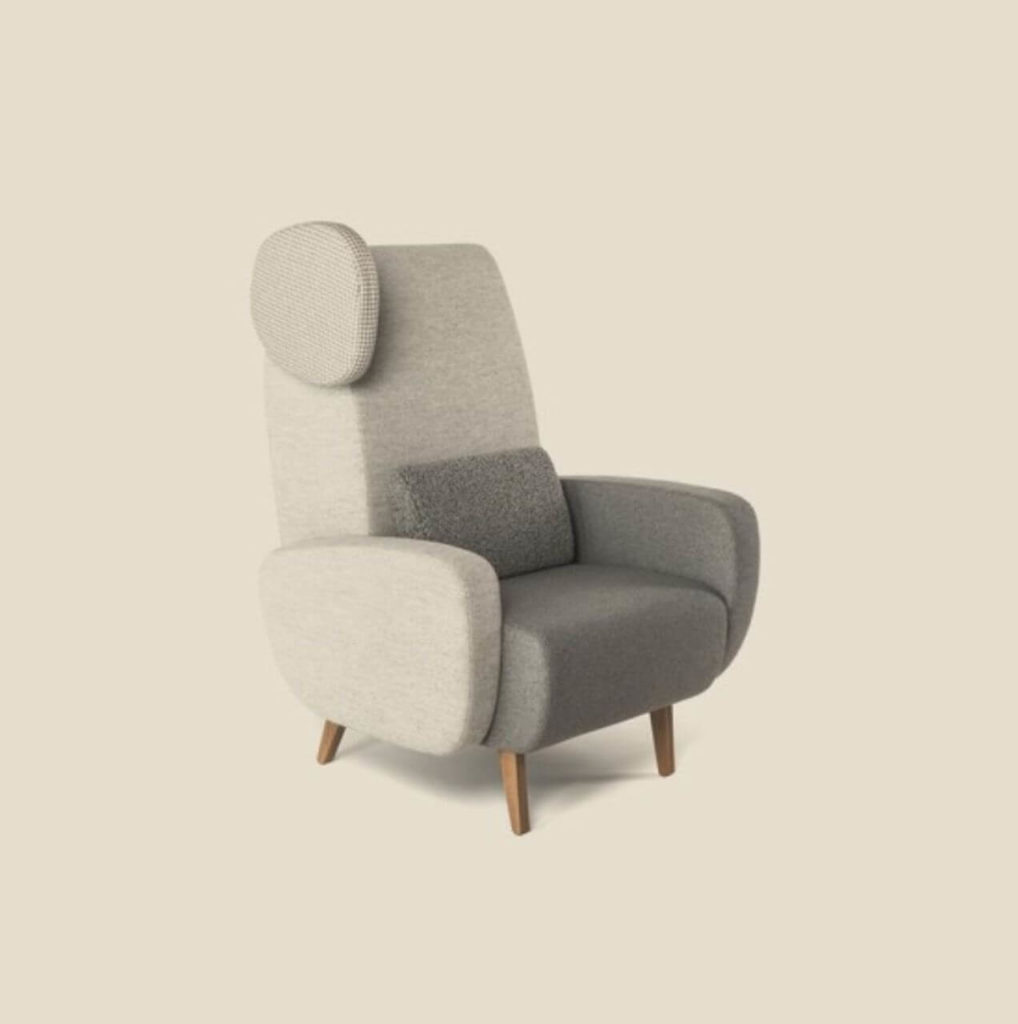 A comfy armchair made of soft light-grey material. Its seat is positioned quite low, and it has four small wooden legs. The way the armrest and backrest are combined, together with an element that looks like an ear, which is attached to the side of the backrest, make the whole thing look like a Teddy Bear from afar.