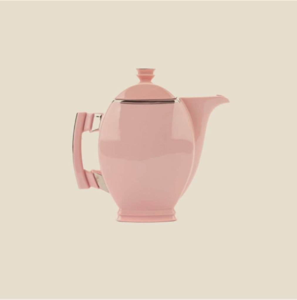 A pink teapot with a golden frieze between the main part and a lid.