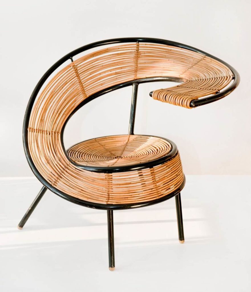 An asymmetrical wicker chair resembling a letter G.