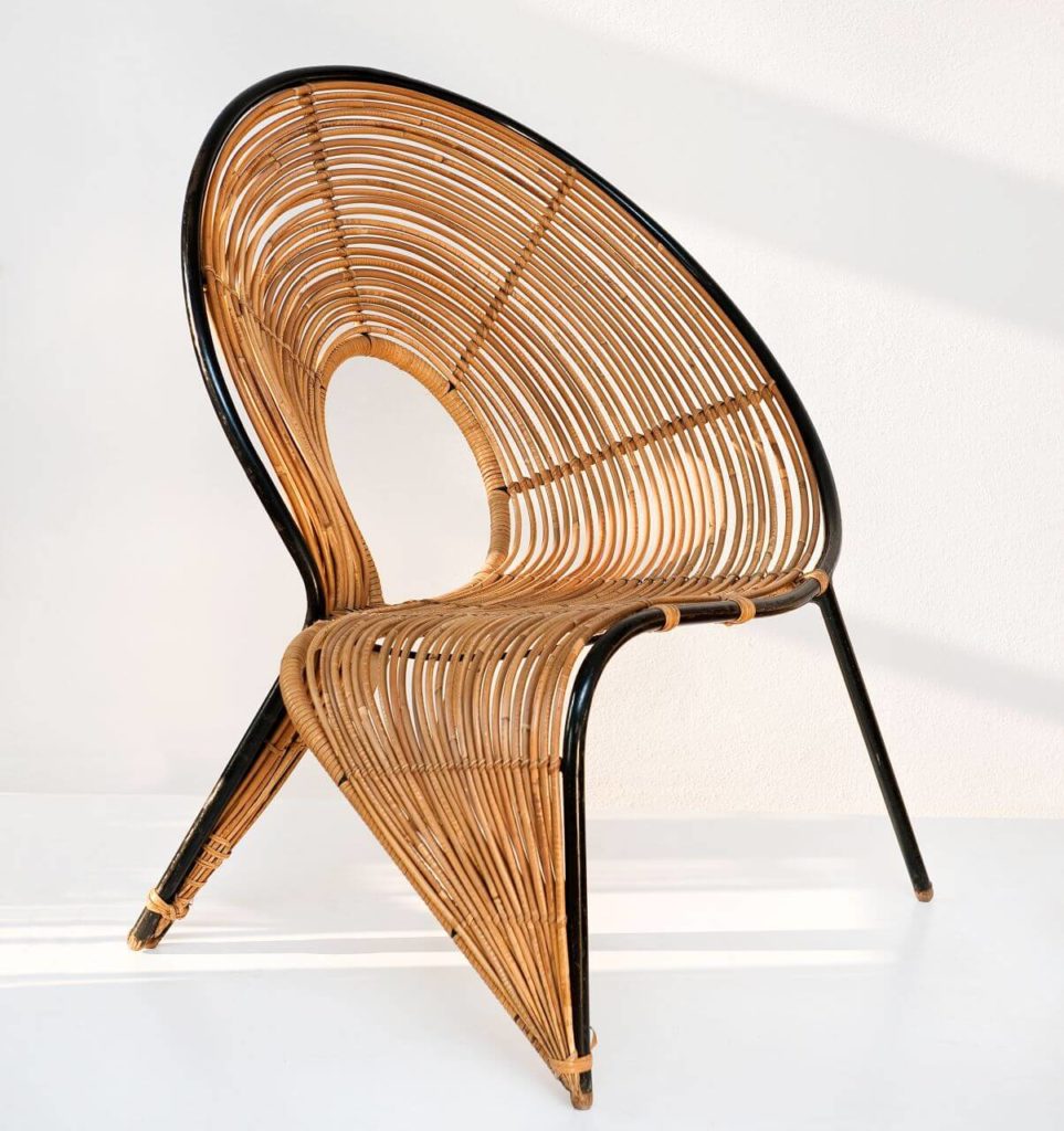 An asymmetrical wicker chair resembling a letter Q.