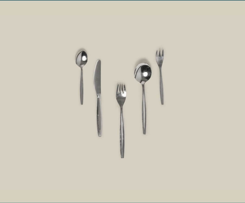 A set of silver cutlery arranged in parallel, side by side. From left to right: teaspoon, knife, fork, spoon, and a small fork. All items have rounded edges.